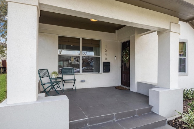 doorway to property featuring stucco siding