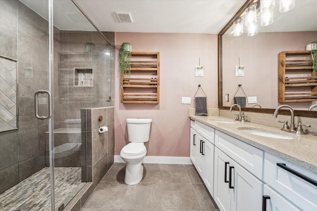 full bath with visible vents, a stall shower, toilet, and a sink