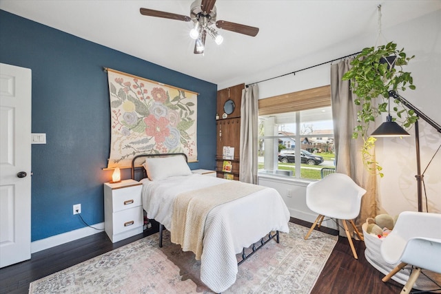 bedroom featuring ceiling fan, baseboards, and wood finished floors