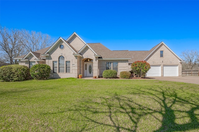 view of front of property with a front lawn, brick siding, driveway, and a shingled roof