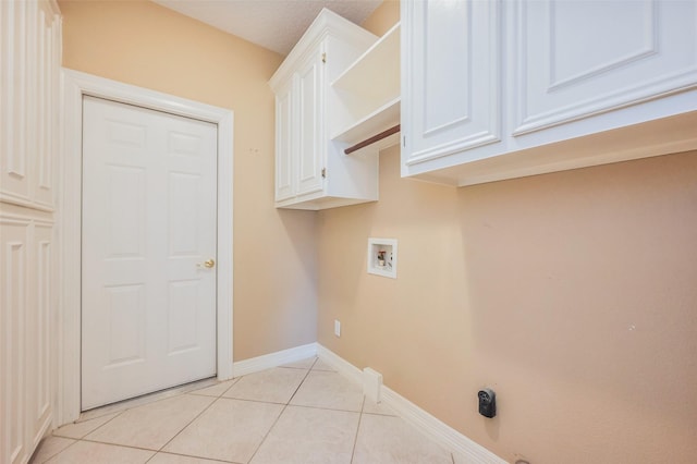 laundry area with washer hookup, light tile patterned flooring, cabinet space, and baseboards