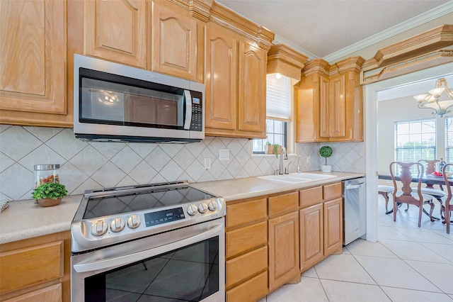 kitchen featuring light countertops, ornamental molding, appliances with stainless steel finishes, light tile patterned flooring, and a sink