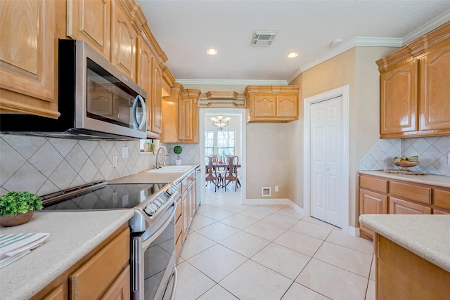 kitchen featuring visible vents, ornamental molding, stainless steel appliances, and a sink