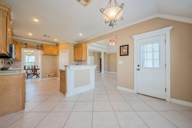 kitchen with tasteful backsplash, visible vents, light countertops, ornamental molding, and light tile patterned floors