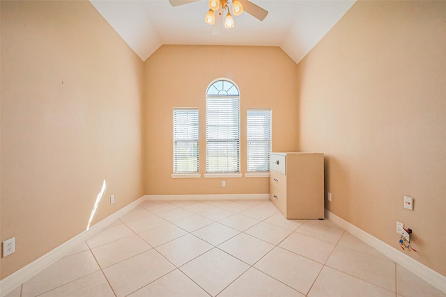 spare room with light tile patterned floors, baseboards, a ceiling fan, and vaulted ceiling