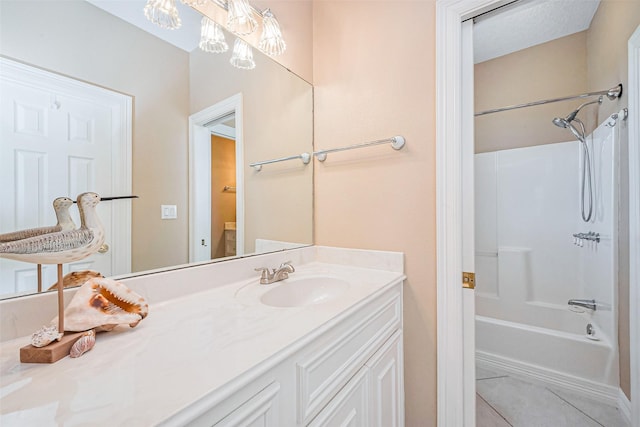 bathroom with tile patterned floors, washtub / shower combination, a notable chandelier, and vanity