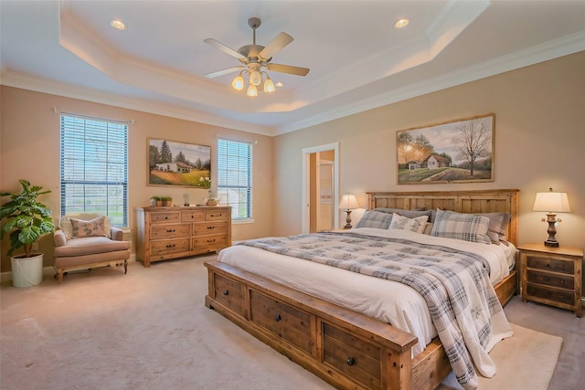 bedroom featuring a tray ceiling, ornamental molding, and light carpet