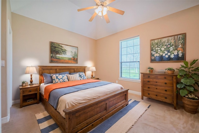 bedroom with light colored carpet, a ceiling fan, and baseboards