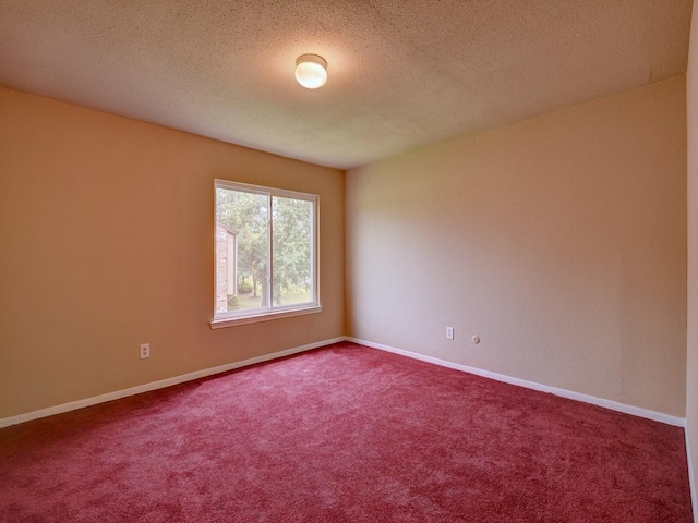 carpeted spare room with baseboards and a textured ceiling