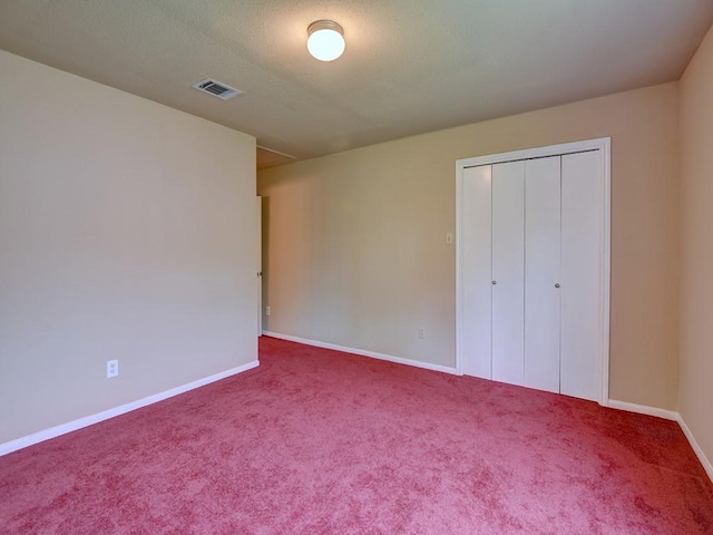 unfurnished bedroom featuring visible vents, carpet floors, baseboards, and a closet