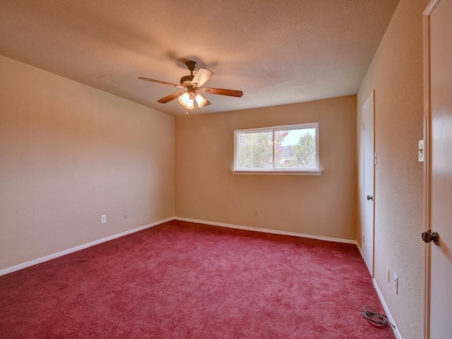 carpeted empty room with a ceiling fan, baseboards, and a textured ceiling