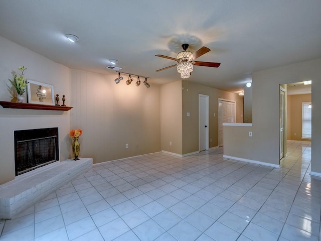 unfurnished living room with baseboards, visible vents, light tile patterned flooring, ceiling fan, and a glass covered fireplace