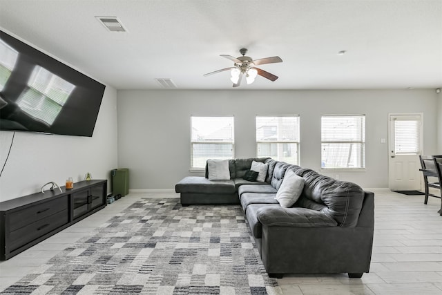 living area with visible vents, a healthy amount of sunlight, and a ceiling fan