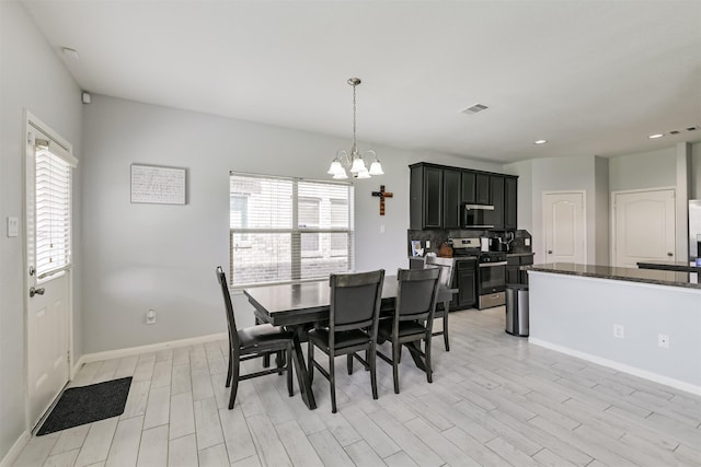 dining area featuring visible vents, plenty of natural light, an inviting chandelier, and light wood finished floors