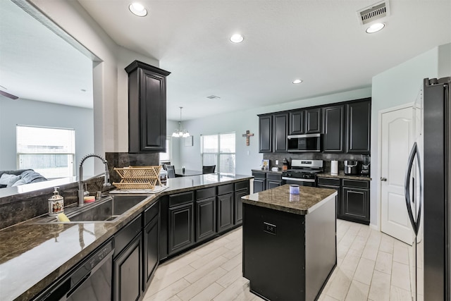 kitchen featuring visible vents, a sink, tasteful backsplash, stainless steel appliances, and dark cabinets