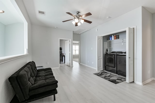 living area with visible vents, light wood-style floors, separate washer and dryer, baseboard heating, and attic access