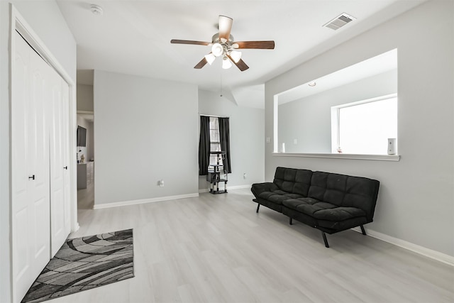 living area featuring light wood-style flooring, baseboards, visible vents, and a wealth of natural light