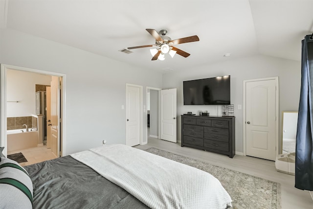 bedroom featuring vaulted ceiling, connected bathroom, visible vents, and ceiling fan