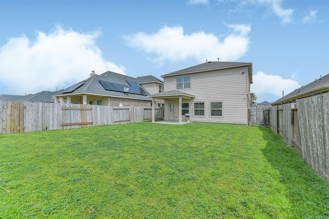 rear view of property featuring a fenced backyard, a patio, and a yard