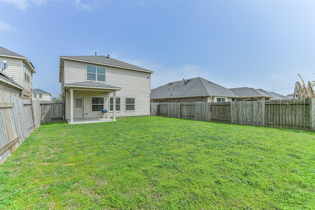 back of property with a patio, a yard, and a fenced backyard