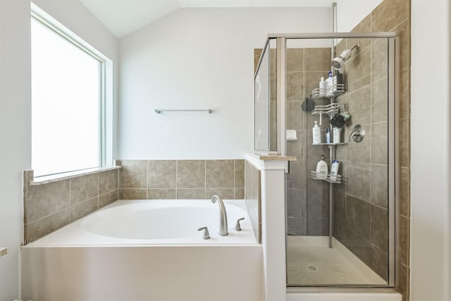 bathroom featuring a shower stall, a bath, and vaulted ceiling