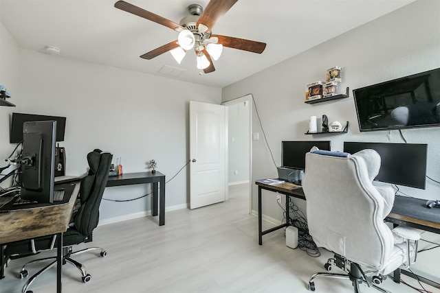 office space featuring a ceiling fan, baseboards, and wood finished floors