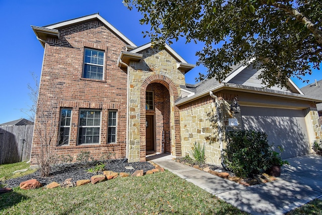 traditional-style home with driveway, stone siding, fence, an attached garage, and brick siding