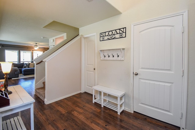 interior space with baseboards, a ceiling fan, and wood finished floors