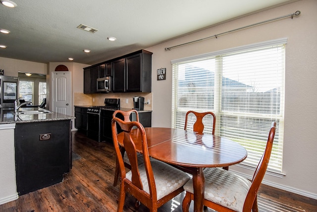 dining space with dark wood-style floors, visible vents, recessed lighting, and a textured ceiling