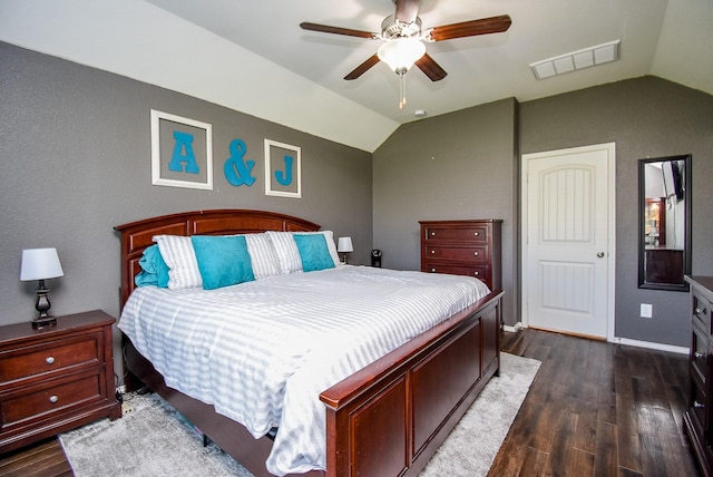 bedroom with visible vents, lofted ceiling, baseboards, and dark wood-style floors