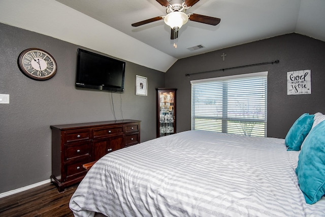 bedroom featuring a ceiling fan, dark wood-style floors, visible vents, baseboards, and vaulted ceiling