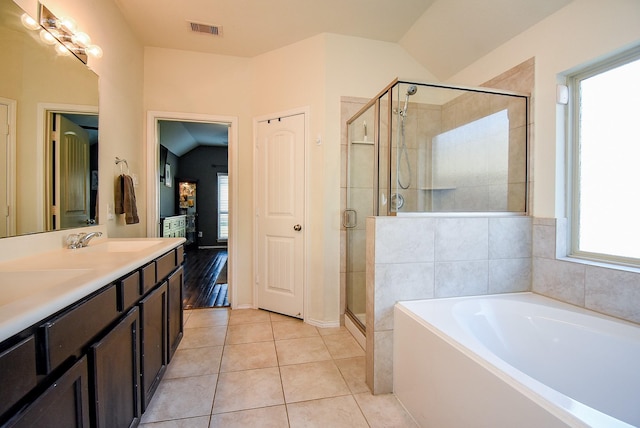 full bath with a garden tub, visible vents, lofted ceiling, a sink, and tile patterned floors