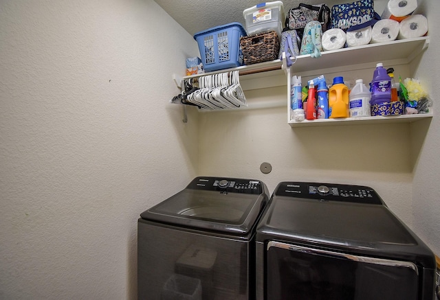 washroom with washing machine and dryer, laundry area, and a textured wall