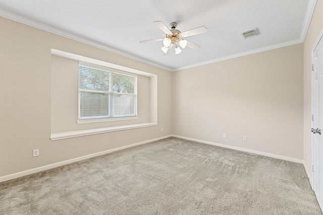 carpeted empty room featuring crown molding, baseboards, visible vents, and ceiling fan