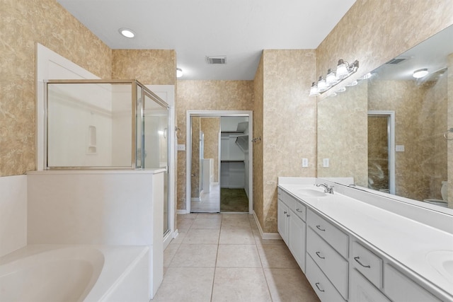 full bath featuring visible vents, double vanity, a stall shower, tile patterned floors, and a sink