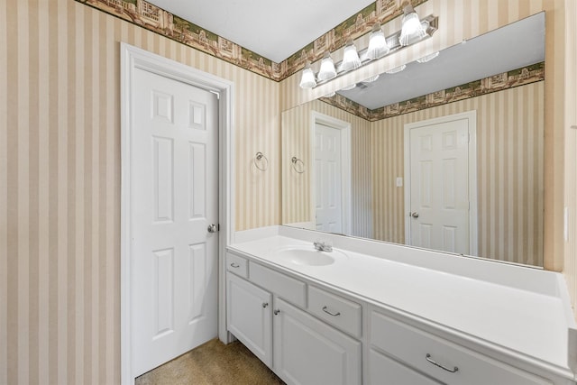 bathroom with wallpapered walls and vanity