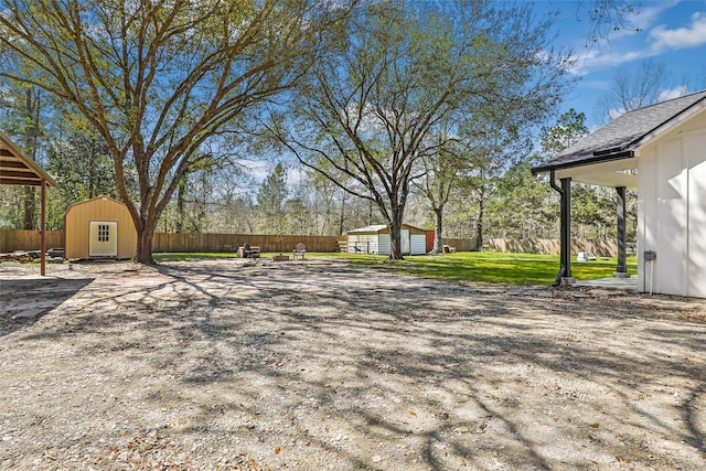 view of yard featuring a storage unit, a fenced backyard, and an outdoor structure