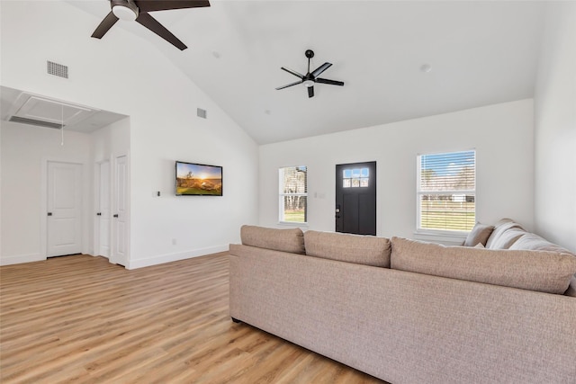 living room with attic access, visible vents, a wealth of natural light, and ceiling fan