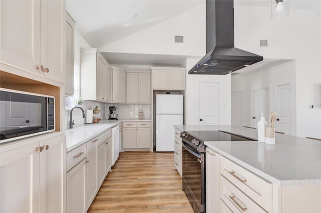 kitchen with lofted ceiling, a sink, extractor fan, black appliances, and light wood-type flooring