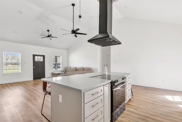 kitchen featuring a wealth of natural light, open floor plan, electric stove, and island range hood