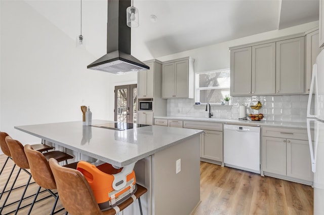 kitchen featuring gray cabinetry, a sink, a center island, ventilation hood, and white appliances