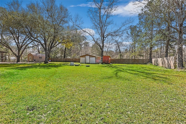 view of yard with a storage shed, a fenced backyard, and an outdoor structure