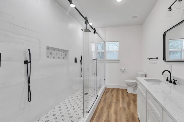 full bathroom featuring visible vents, toilet, a stall shower, wood finished floors, and vanity