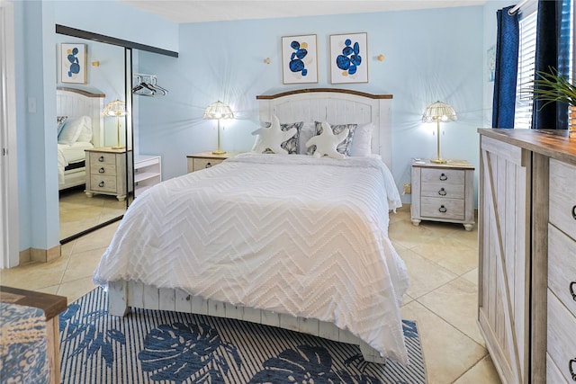 bedroom with light tile patterned floors and baseboards