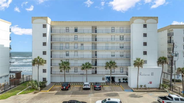 view of building exterior with uncovered parking and fence