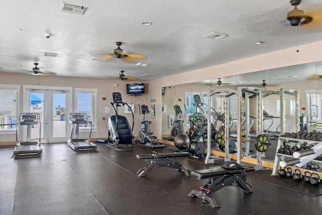 exercise room with visible vents, plenty of natural light, a textured ceiling, and ceiling fan