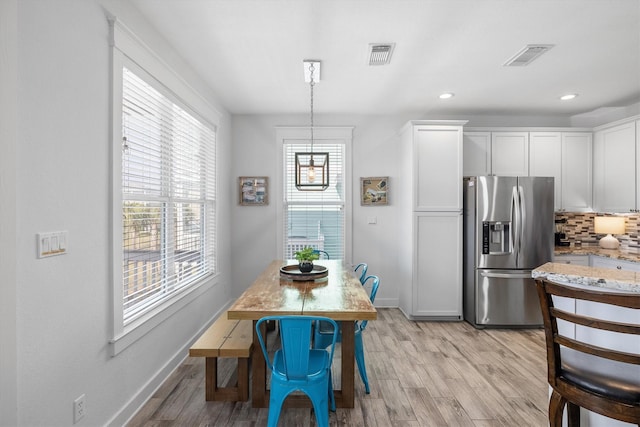 dining area featuring light wood finished floors, visible vents, recessed lighting, and baseboards