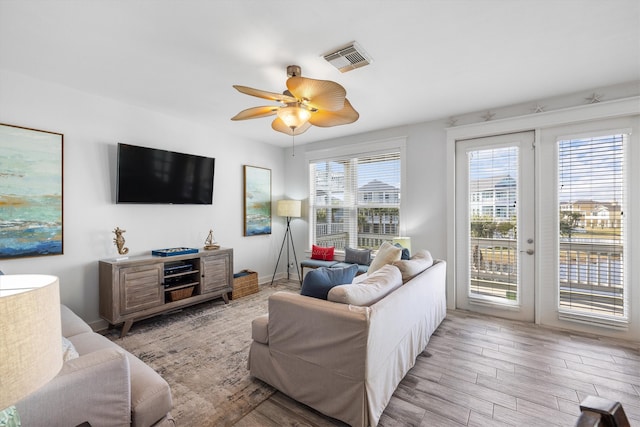 living area with visible vents, wood finished floors, and a ceiling fan