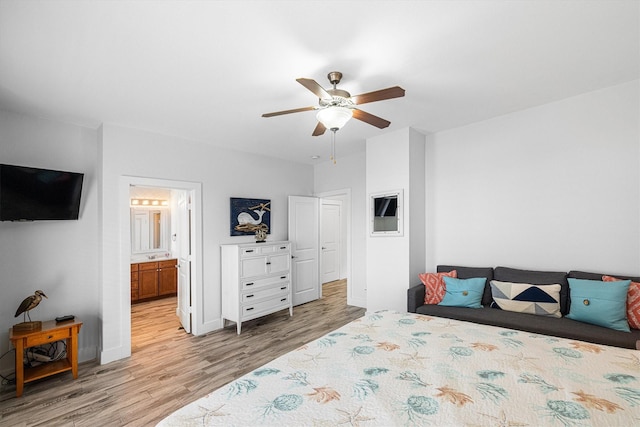 bedroom with ceiling fan, baseboards, ensuite bath, and wood finished floors