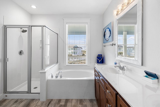 bathroom featuring a shower stall, vanity, a healthy amount of sunlight, and wood finished floors